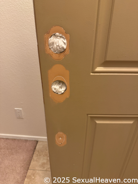 A front entry door with the locks removed.