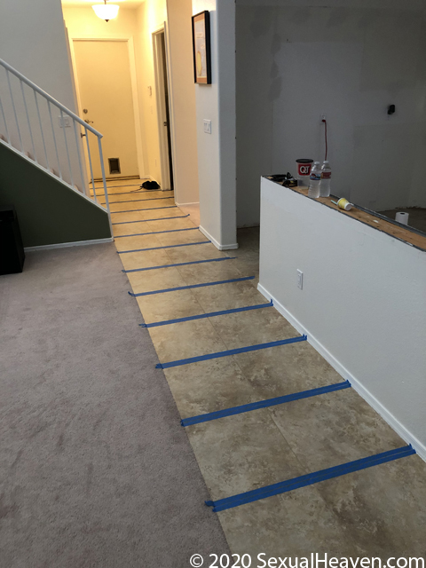 Tape on either side of a grout line on the floor.