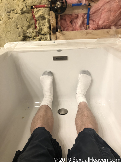 Feet inside of a bathtub.