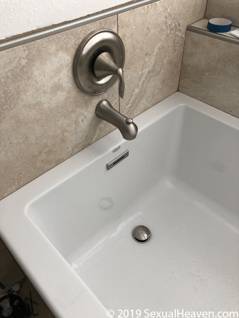 A picture of a tub spout and handle.