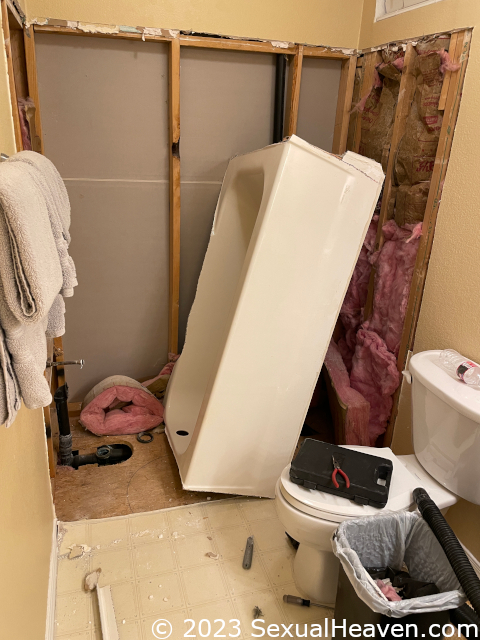 A cut up fiberglass tub leaning on the wall.